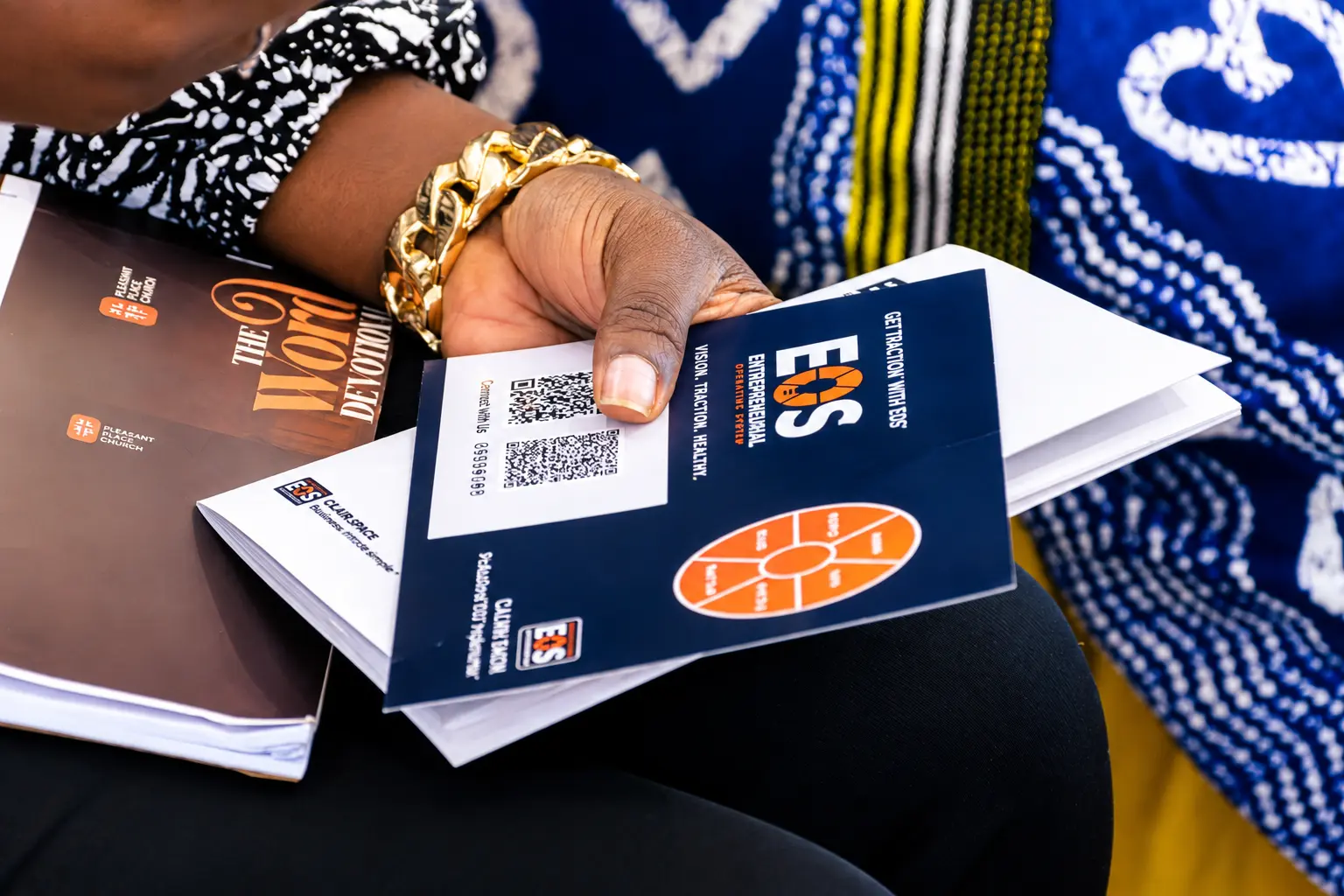 Attendee holding EOS® event booklets at a business conference
