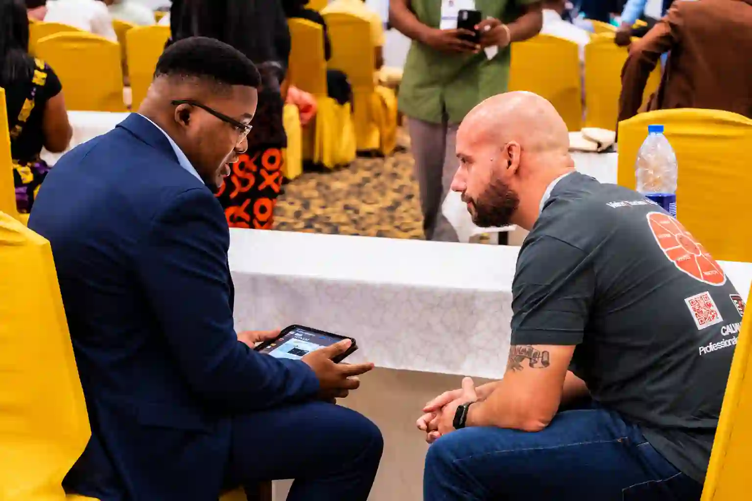 Calvin Smith in a focused one-on-one conversation with a founder at a conference